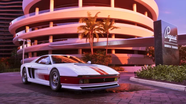 White Ferrari with red racing stripes parked in front of a circular, multi-level hotel parking structure at a Las Vegas resort.